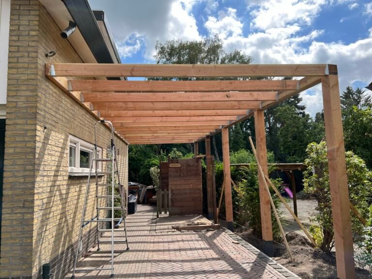 Houten carport in aanbouw aan de zijkant van een woning