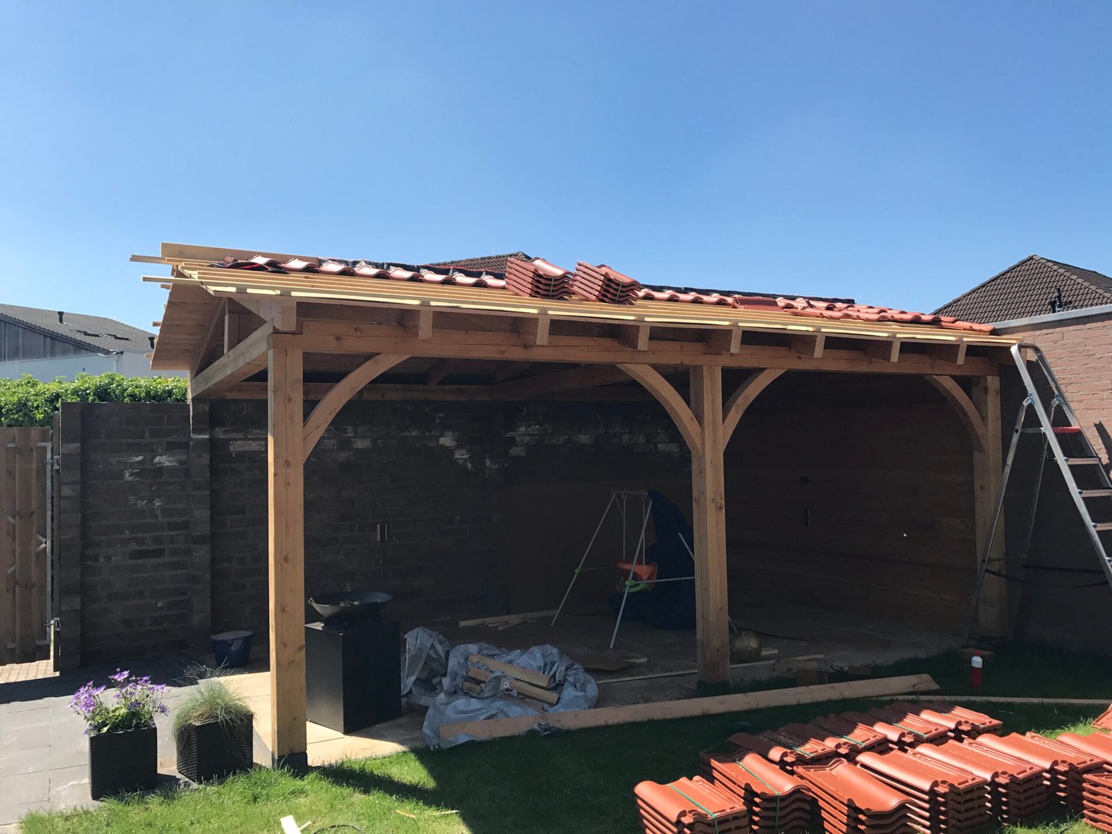 Houten overkapping in aanbouw met pannendak